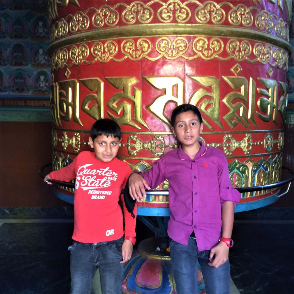 Swayambunath – twee Nepalese jongens voor een grote gebedsmolen