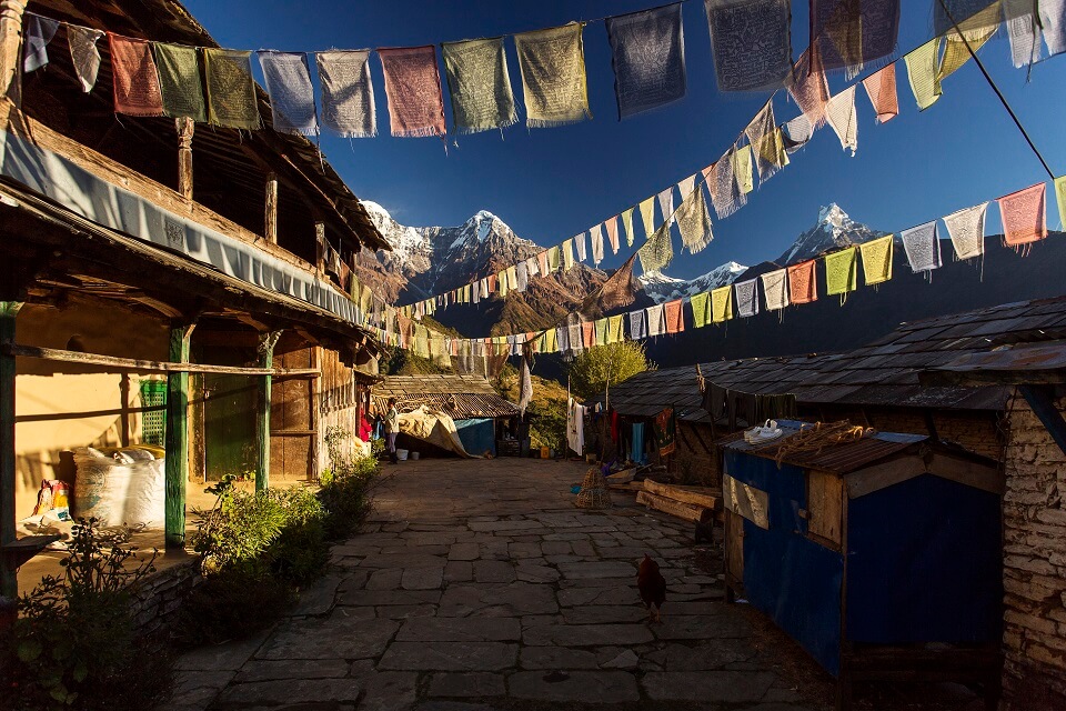 Poon Hill & Muldai Peak trekking – gebedsvlagjes in het dorp Ghandruk met zicht op de Himalayas
