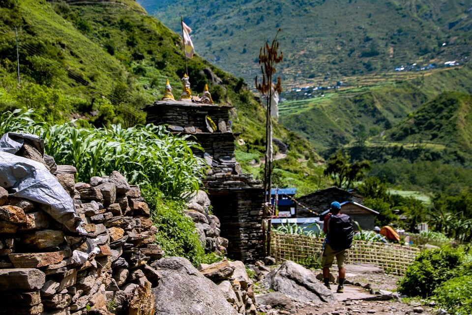 Manaslu met Tsum vallei trek – trekker wandelt naast een chÃ¶rten in de Tsum vallei